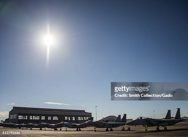 Clear skies and bright sun shines down on a row of 125th Fighter Wing F-15s from Jacksonville Florida, on the Eglin Air Force Base flightline,...