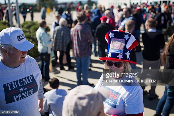 Supporter of Republican presidential candidate Donald Trump wears an America-themed hat while waiting outside the Mohegan Sun Arena before a rally...