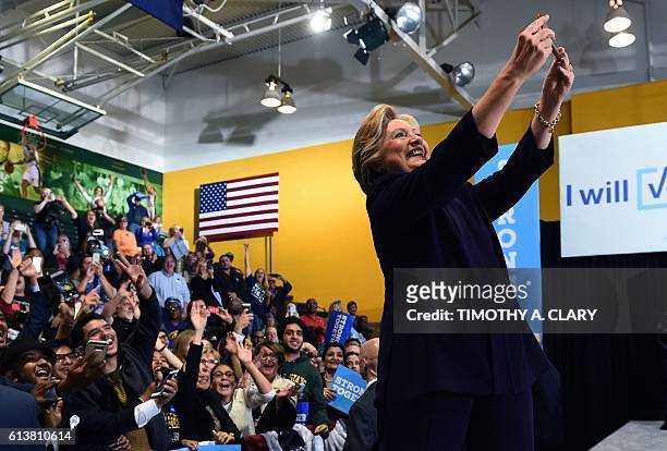 Democrat presidential nominee Hillary Clinton takes a selfie with attendees at a rally at Wayne State University in Detroit, Michigan October 10,...