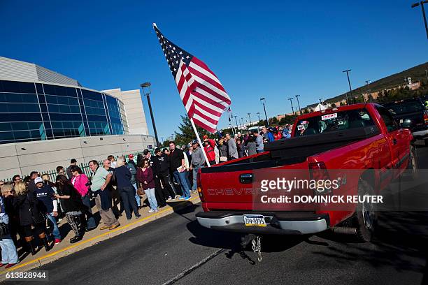 Red pickup truck trailing an American flag passes supporters of Republican presidential candidate Donald Trump outside the Mohegan Sun Arena before a...