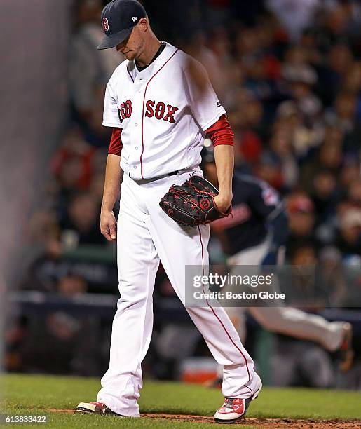 Boston Red Sox pitcher Clay Buchholz hangs his head as the Cleveland Indians player Jose Ramirez heads for the plate behind him, the first of two...