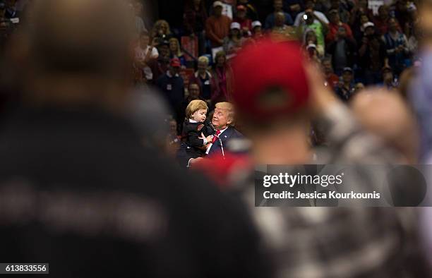 Republican presidential nominee Donald Trump brings a child from the audience on stage at a campaign rally on October 10, 2016 in Wilkes-Barre,...