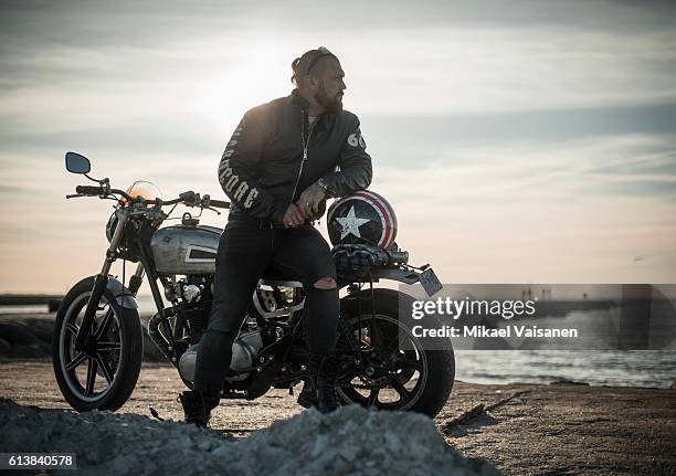 bearded man with custom motorcycle - biker photos et images de collection