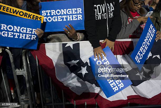 Attendees hold signs as they wait in the crowd during a campaign event for Hillary Clinton, 2016 Democratic presidential nominee, in Columbus, Ohio,...