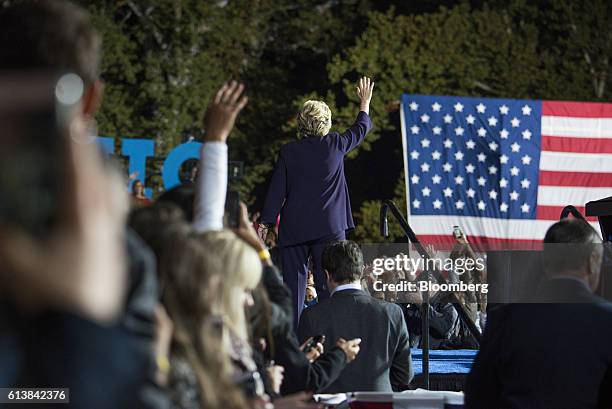 Hillary Clinton, 2016 Democratic presidential nominee, center, waves to the crowd after speaking during a campaign event in Columbus, Ohio, U.S., on...