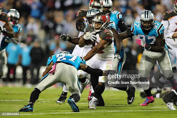 Tampa Bay Buccaneers running back Jacquizz Rodgers tries to elude Carolina Panthers defensive back Robert McClain during the first half between the...