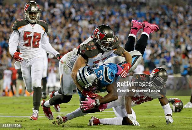 Fozzy Whittaker of the Carolina Panthers runs the ball against Chris Conte and Jude Adjei-Barimah of the Tampa Bay Buccaneers in the 2nd half during...
