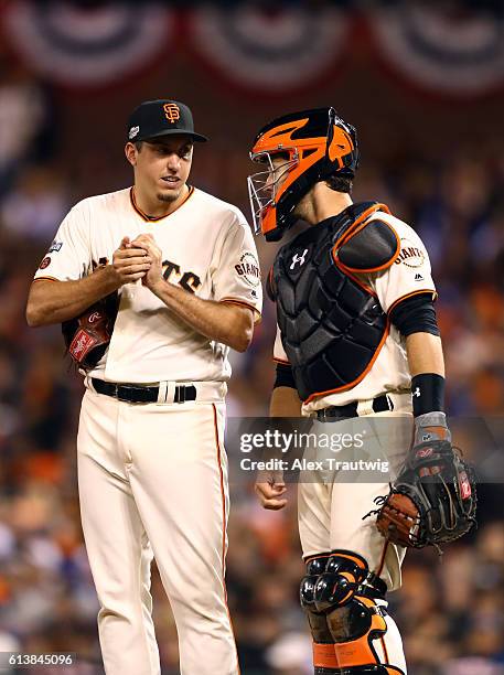 Derek Law and Buster Posey of the San Francisco Giants meet on the mound during Game 3 of NLDS against the Chicago Cubs at AT&T Park on Monday,...