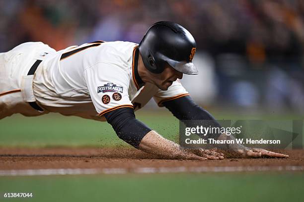 Conor Gillaspie of the San Francisco Giants slides into third after hitting a two-run triple in the eighth inning against the Chicago Cubs during...