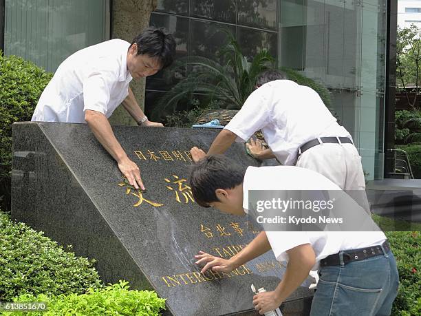 Taiwan - Workers clean a stone sign in front of the Interchange Association, Japan's de facto embassy in Taiwan, in Taipei on Sept. 1 after the sign...