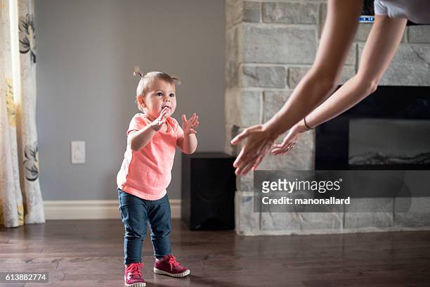 baby girl's first step with her mother - baby boot stock pictures, royalty-free photos & images