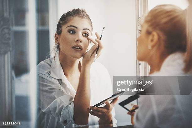 bit of eye shadow and we're good to go. - applying makeup with brush stock pictures, royalty-free photos & images