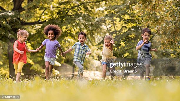 kleine glückliche kinder mit spaß beim laufen in der natur. - holding hands kids stock-fotos und bilder