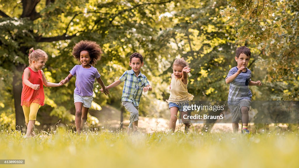Small happy kids having fun while running in nature.