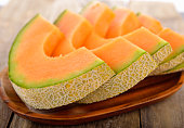 Fresh melons sliced on wooden plate
