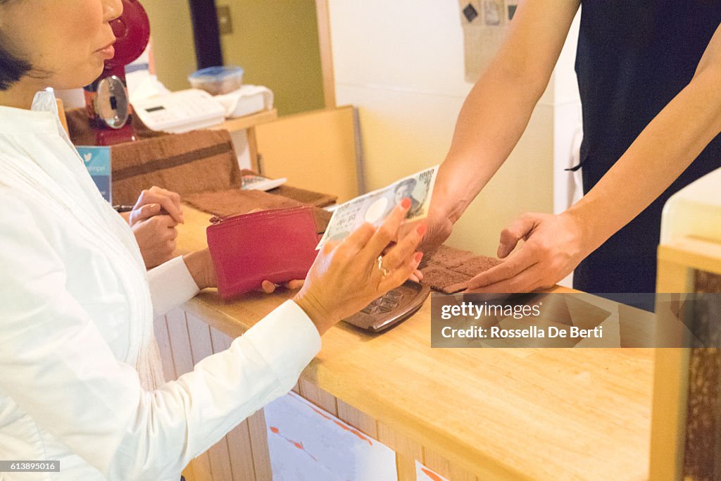 カフェで現金で支払いをする日本の女性