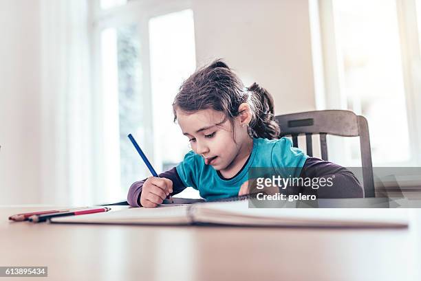 concentrated cute little girl drawing at desk with color pen - children drawing white background bildbanksfoton och bilder