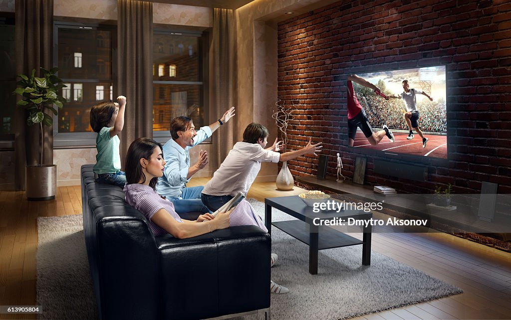 Family with children cheering and watching Relay race on TV