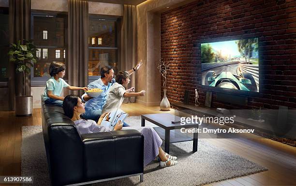 familia con niños viendo sports car race en la televisión - familia viendo television fotografías e imágenes de stock