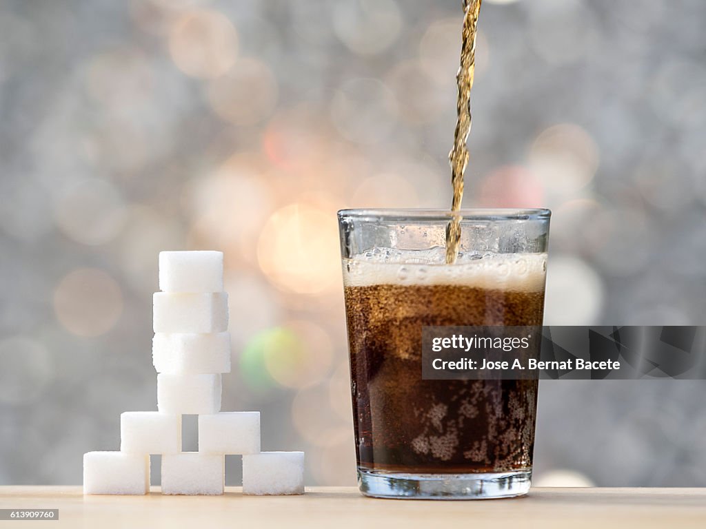 Filling a glass with cola and its equivalent in sugar cubes