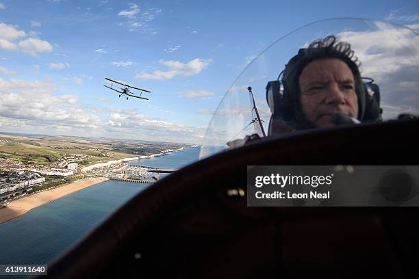 Tiger Moth DH82A, flown over the English coast by pilot Ian Perry, is seen over the shoulder of pilot Pedro Langdon during a promotional event for...