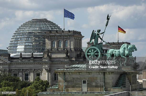 The Quadriga statue stands on top of the Brandenburg Gate as the cupola of the Reichstag is seen behind on June 28, 2016 in Berlin, Germany. Both are...