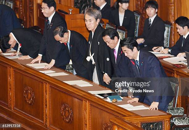 Prime Minister Shinzo Abe and his Cabinet ministers bow to the floor of the House of Councillors in Tokyo, which approved a 4.11 trillion yen...