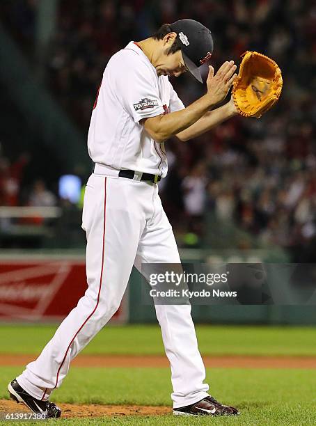 Boston Red Sox reliever Koji Uehara celebrates after fine fielding by a teammate during the eighth inning in Game 3 of the American League Division...