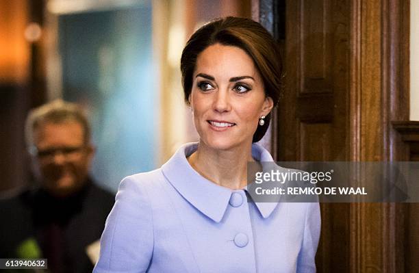 Britain's Catherine, the Duchess of Cambridge, walk through a set doors at the residence of the British Ambassador in The Hague on October 11 during...