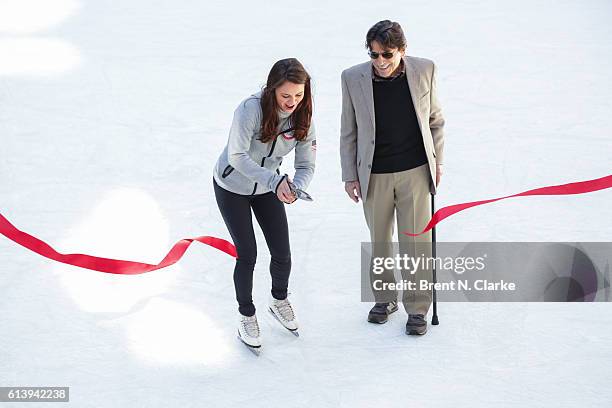 Olympic figure skating champion Sasha Cohen and choreographer Edward Villella cut the ribbon during The Rink at Rockefeller Center's 80th Anniversary...