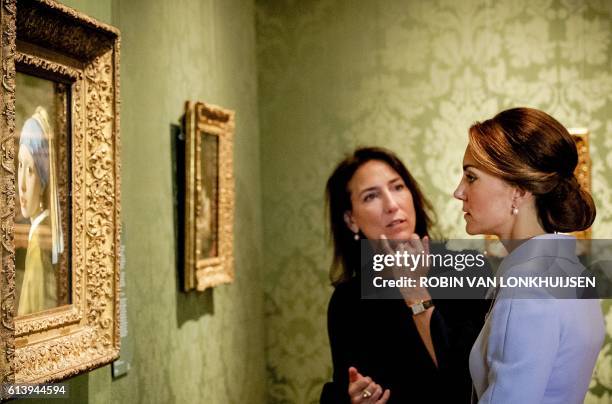 Britain's Catherine, the Duchess of Cambridge, looks at the famous Dutch 17th century painting "Girl with a Pearl Earring" by Johannes Vermeer during...