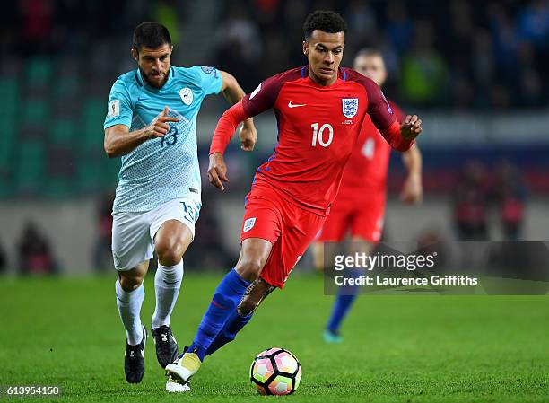 Dele Alli of England runs with the ball under pressure from Bojan Jokic of Slovenia during the FIFA 2018 World Cup Qualifier Group F match between...