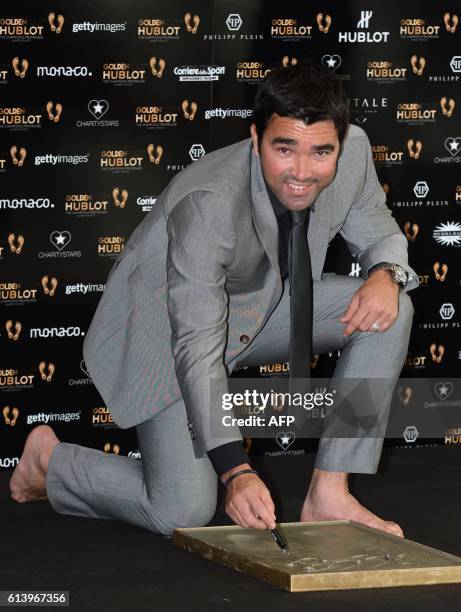 Anderson Luís de Souza, known as Deco, retired Brazilian born-Portuguese footballer, signs the mold of his foot print for the "Golden Football...