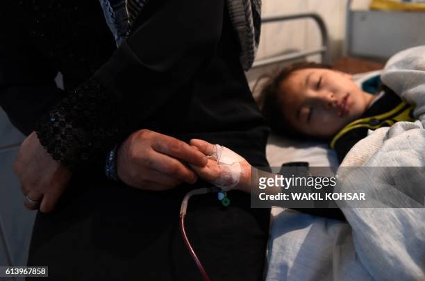 An Afghan wounded girl receive treatment at the Ali Abad hospital after an attack by gunmen inside the Kart-e- Sakhi shrine in Kabul on October 11,...