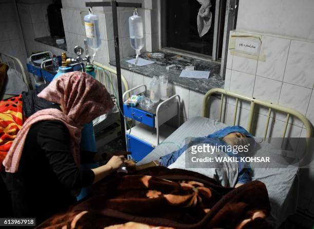An Afghan wounded girl receives treatment at the Ali Abad hospital after an attack by gunmen inside the Kart-e- Sakhi shrine in Kabul on October 11,...