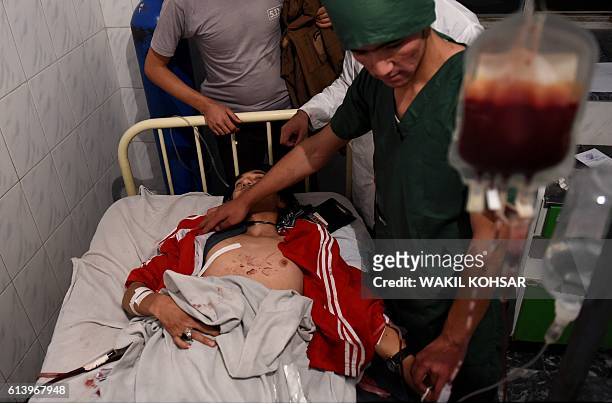 An Afghan wounded man receives treatment at the Ali Abad hospital after an attack by gunmen inside the Kart-e- Sakhi shrine in Kabul on October 11,...