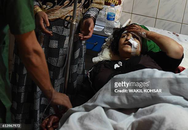 An Afghan wounded woman receives treatment at the Ali Abad hospital after an attack by gunmen inside the Kart-e- Sakhi shrine in Kabul on October 11,...