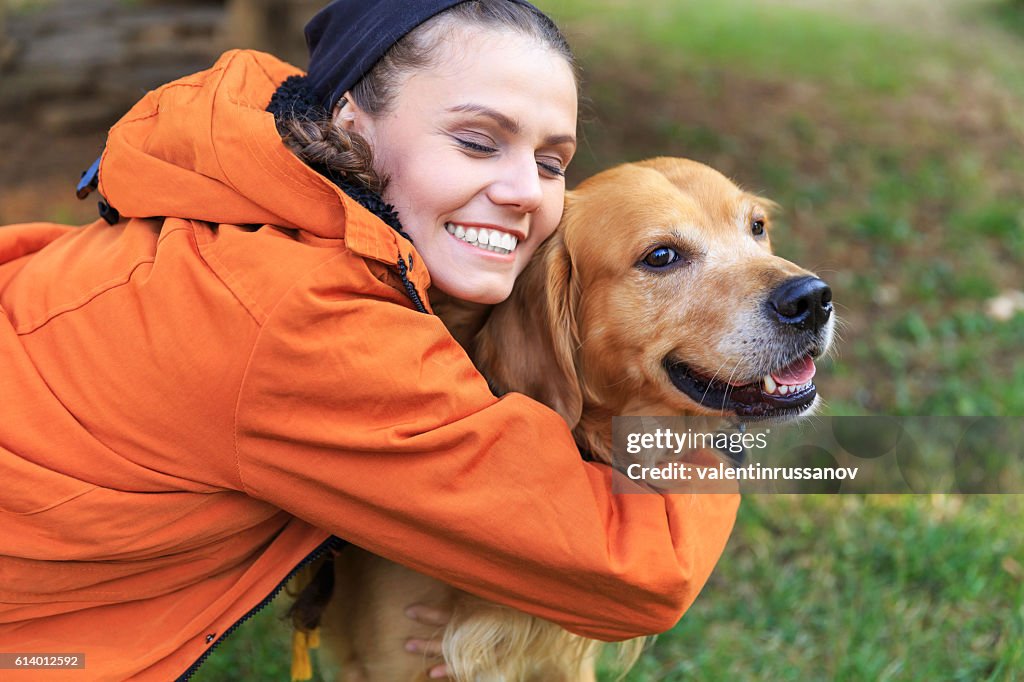 Smiling young woman embracing a dog