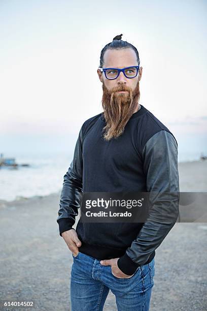 bespectacled bearded handsome male posing by the sea - sumo knot stockfoto's en -beelden