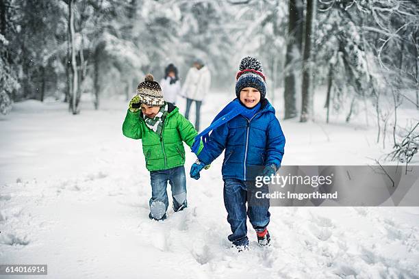 kleine brüder mit familie genießen winterspaziergang im wald. - kids playing snow stock-fotos und bilder