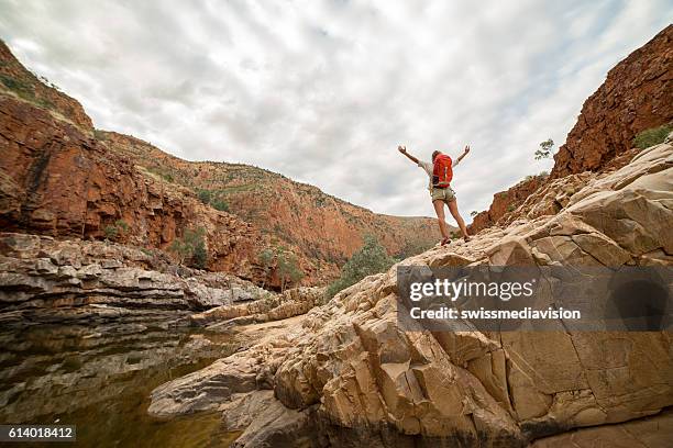 hiker on rock arms outstretched - backpacker road stockfoto's en -beelden