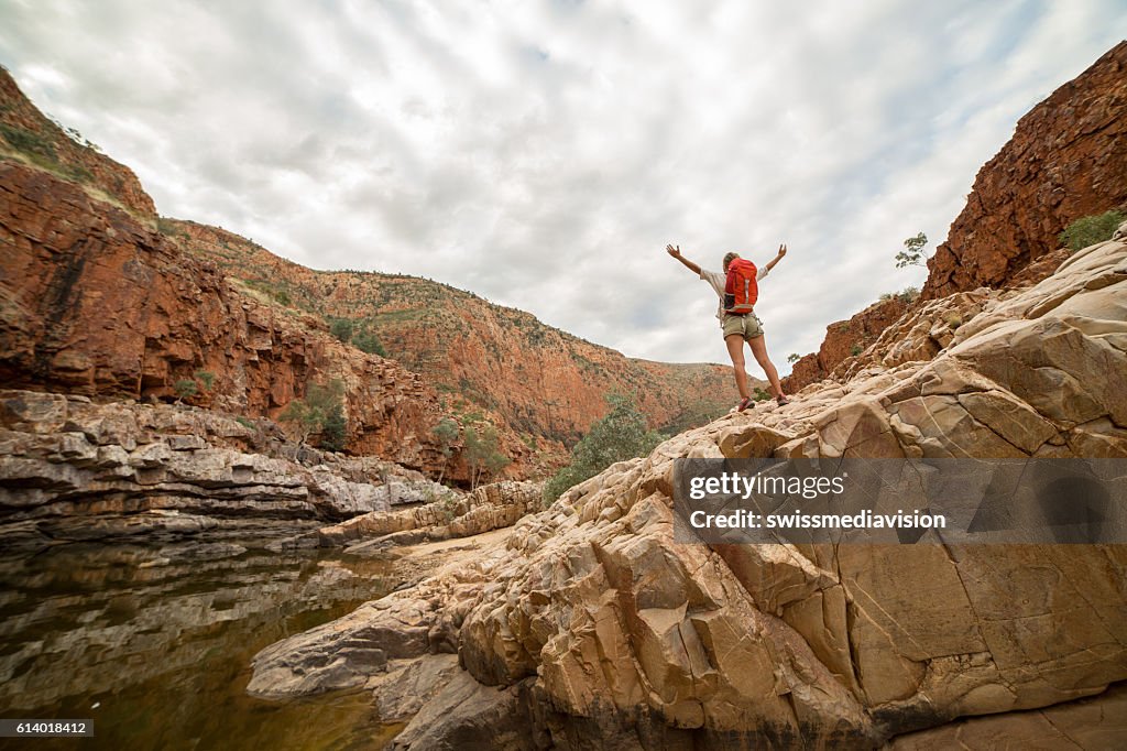 Hiker on rock arms outstretched