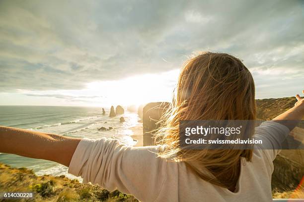 caucasian female arms outstretched at sunset - melbourne parkland stock pictures, royalty-free photos & images