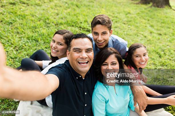 felice famiglia latina che scatta un selfie all'aperto - cinque persone foto e immagini stock