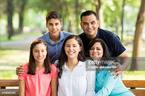 lateinische fünferfamilie umarmt und lächelt vor der kamera - latin father and son stock-fotos und bilder