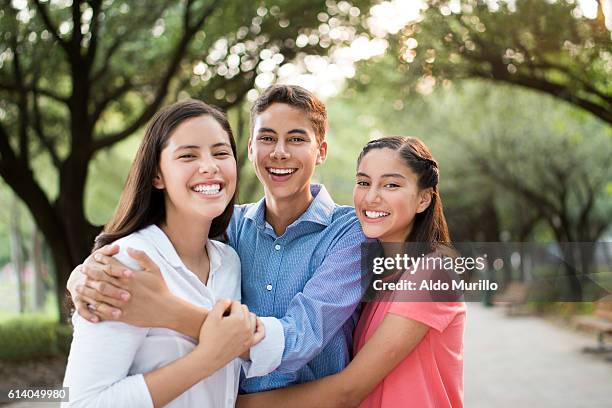 fun latin siblings embracing and smiling - broers en zussen stockfoto's en -beelden