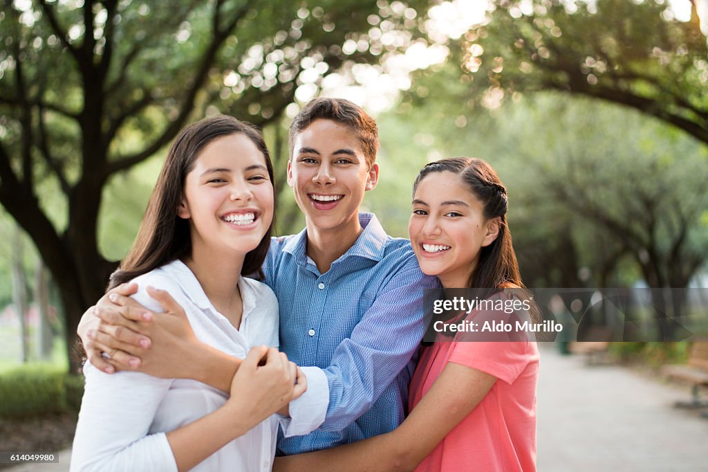 Fun latin siblings embracing and smiling