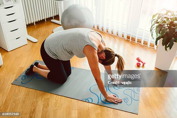 young pregnant woman exercise in her living room. - prenatal yoga stock pictures, royalty-free photos & images