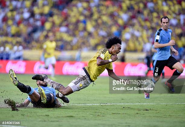 Juan Guillermo Cuadrado of Colombia struggles for the ball with Alvaro Pereira of Uruguay during a match between Colombia and Uruguay as part of FIFA...