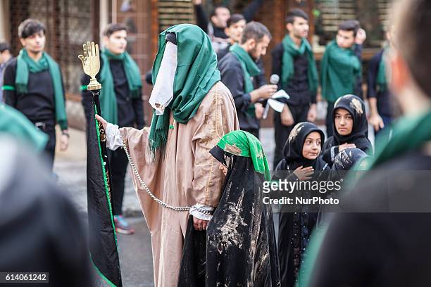 Woman holding up the Hamza/Fatima's hand which represents abundance. Thousands of mourners walk to commemorate the death of Husayn ibn Ali, the...
